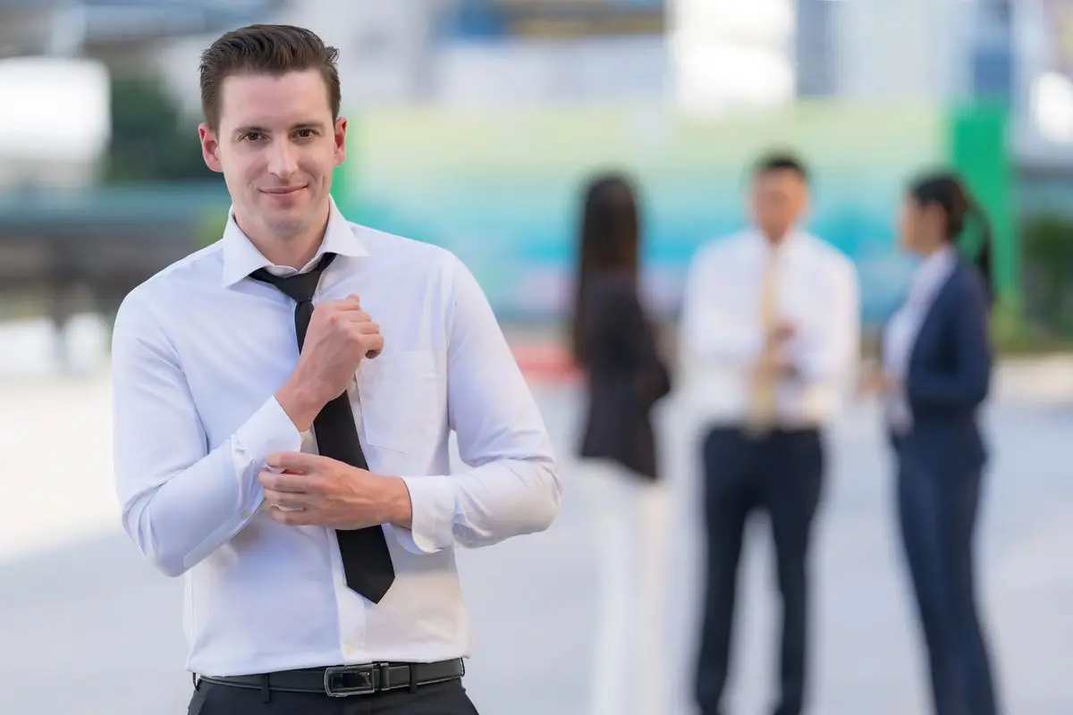 Portrait of successful businessman standing in front of modern office buildings